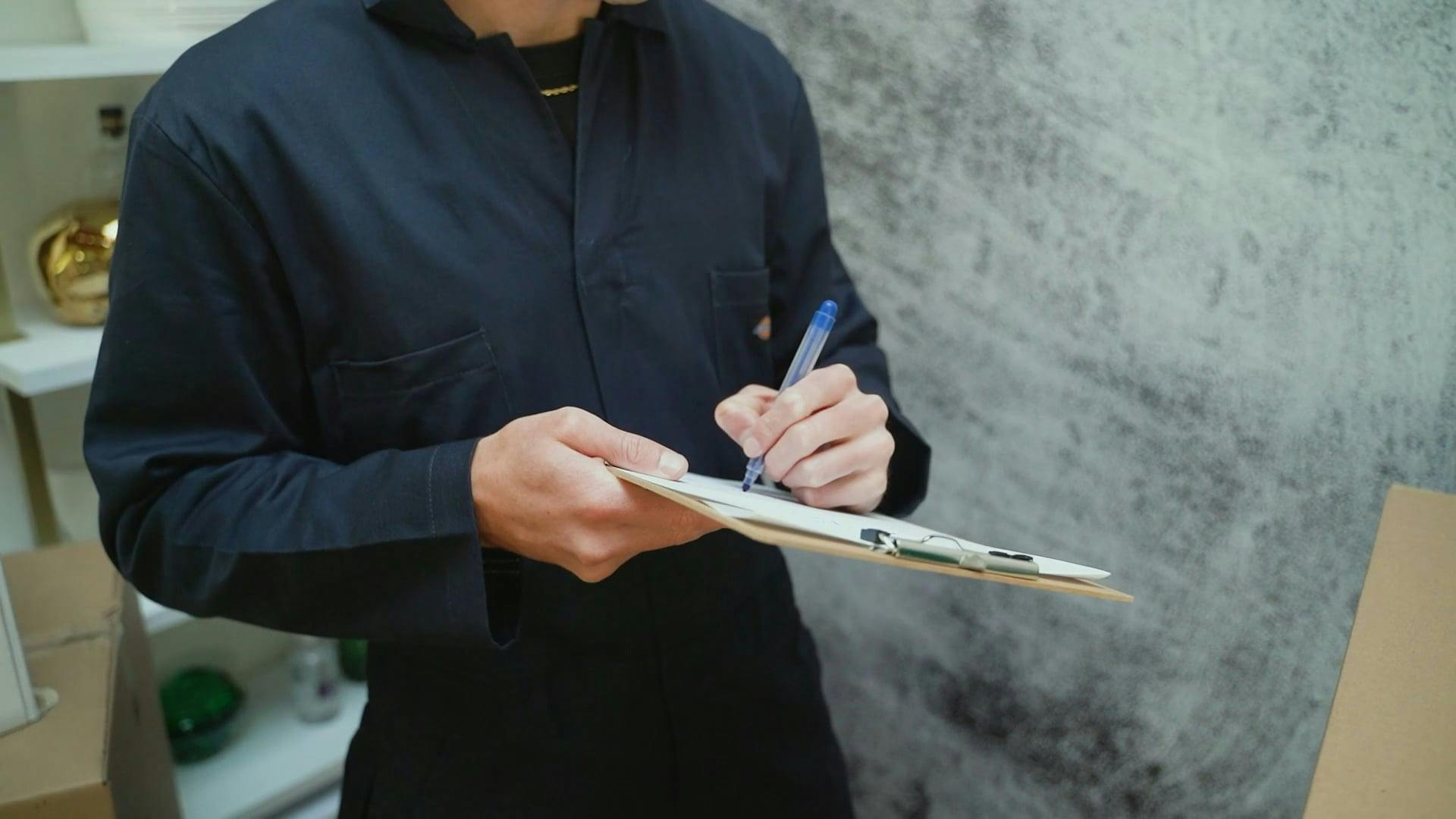 A man holding a clipboard, his face concealed